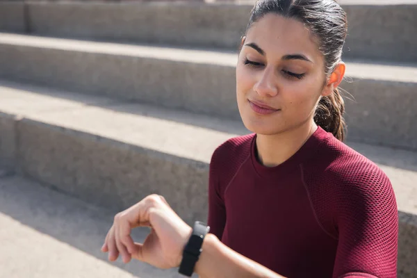 Young woman looking at watch — Stock Photo, Image