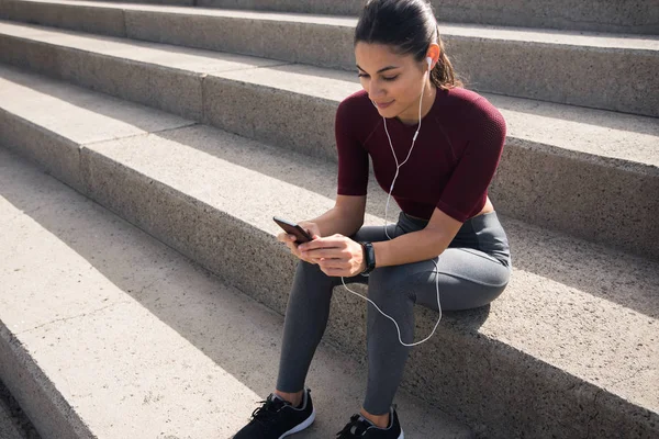 Mladá žena při pohledu na telefon — Stock fotografie