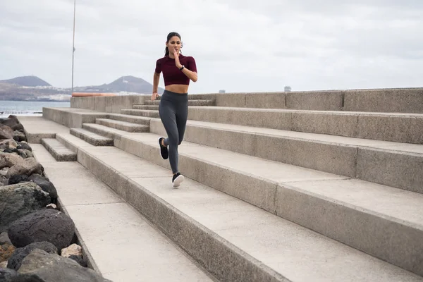 Mujer atractiva corriendo a lo largo del paseo marítimo — Foto de Stock