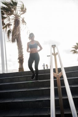 merdivenlerden aşağı çalışan genç kadın