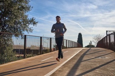 Genç adam işaretli bir yolda koşuyor.