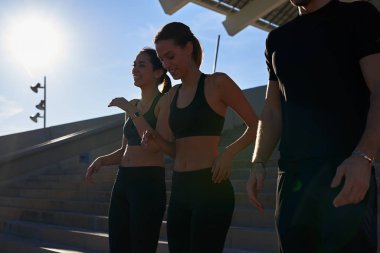 Egzersiz yaparken konuşan üç genç