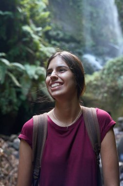Şelalenin önünde gülen genç kadın