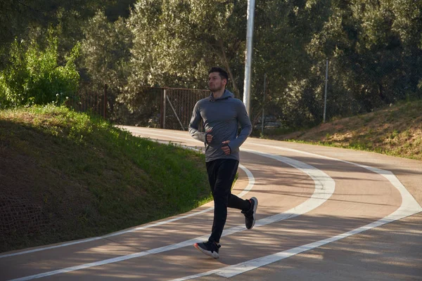 Joven corriendo en una pista atlética — Foto de Stock