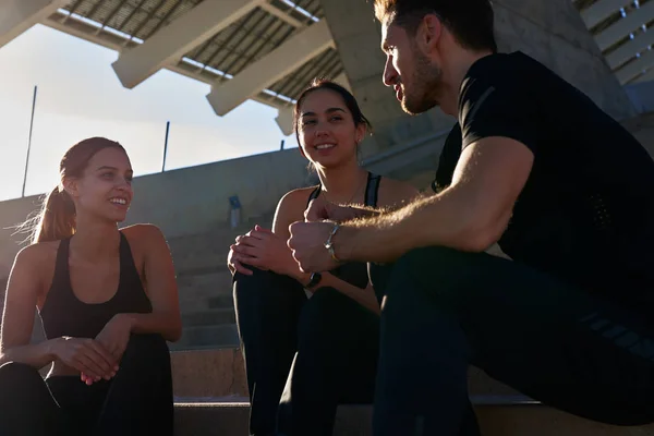 Tres personas hablando mientras están sentadas en las escaleras — Foto de Stock