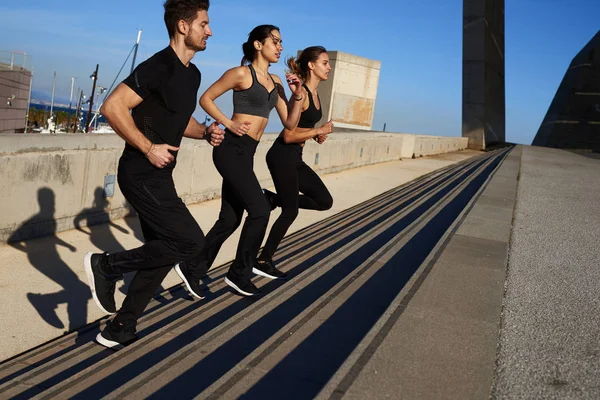 Tres jóvenes subiendo escalones — Foto de Stock