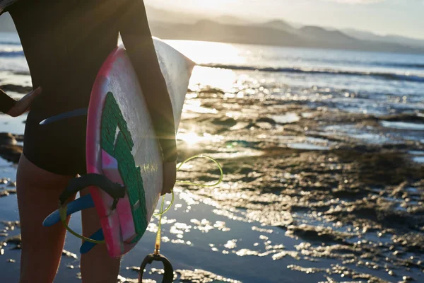 Vista trasera de una surfista femenina en el borde de las aguas — Foto de Stock