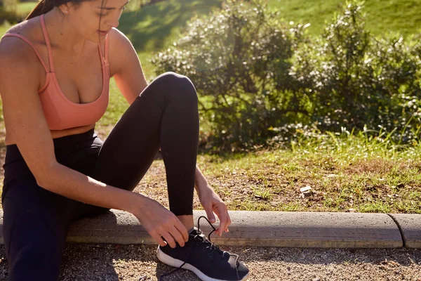 Woman with her leg up leans forward