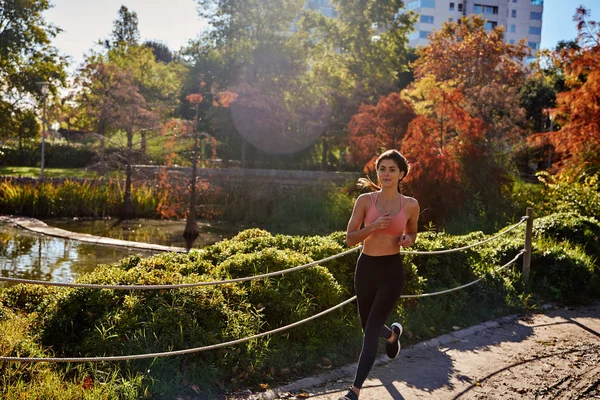 Привлекательная молодая женщина бегает по парку — стоковое фото