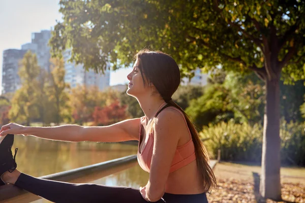 Vrouw stretching haar been spieren op een reling — Stockfoto