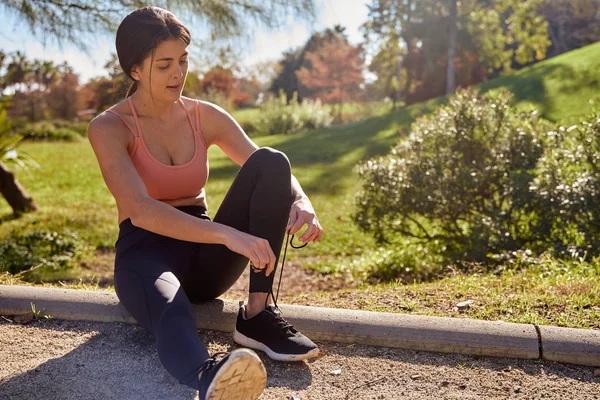 Young woman holds her shoelaces together — Stock Photo, Image