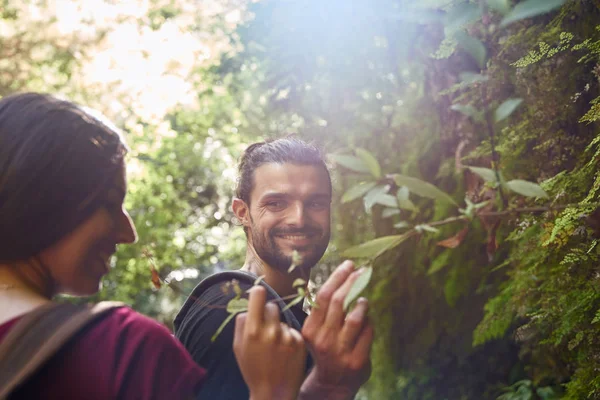 Pareja sonrisa el uno al otro en un bosque — Foto de Stock