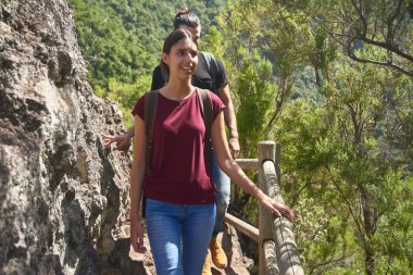 Kaya duvarının yanındaki güvertede genç bir çift.