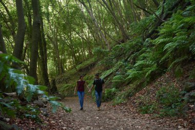 Coupe ormanda el ele yürüyor.