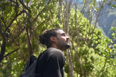 Genç adam dağa bakıyor.