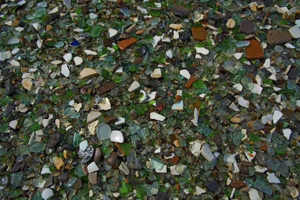 Meeresstrand mit vielen Meeresfelsen und glatten Glasscherben — Stockfoto