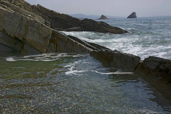 Beach with stones high waves and splashes