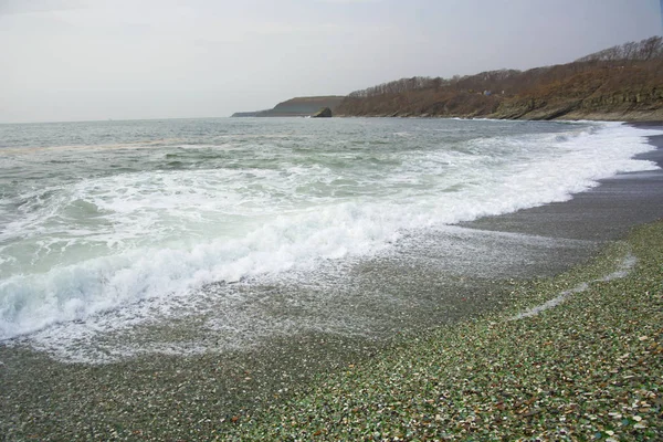 Piękny bezludnej plaży, fale i bryzni na skałach, gładki szklany — Zdjęcie stockowe