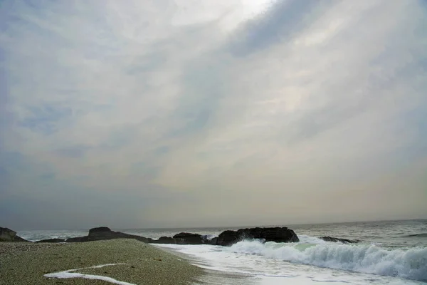 Bella spiaggia deserta, onde e bryzni sulle rocce, vetro liscio — Foto Stock