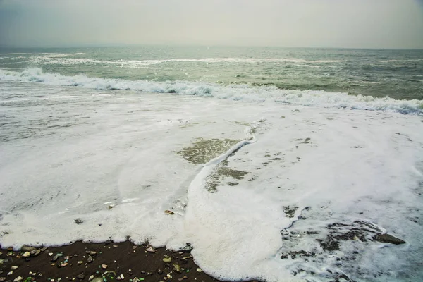 Piękny bezludnej plaży, fale i bryzni na skałach, gładki szklany — Zdjęcie stockowe