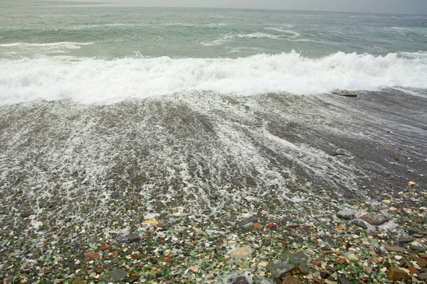 Bela praia deserta, ondas e bryzni nas rochas, vidro liso — Fotografia de Stock