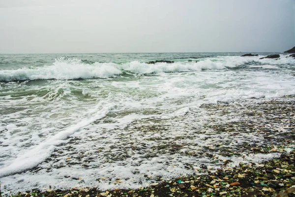 Bela praia deserta, ondas e bryzni nas rochas, vidro liso — Fotografia de Stock