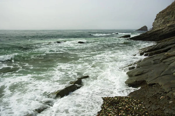 Bela praia deserta, ondas e bryzni nas rochas, vidro liso — Fotografia de Stock