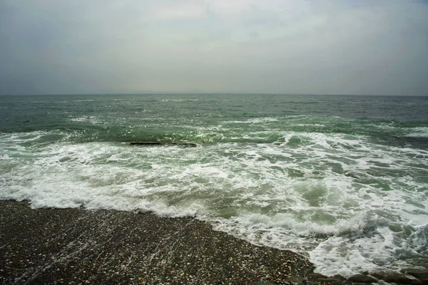 Bela praia deserta, ondas e bryzni nas rochas, vidro liso — Fotografia de Stock