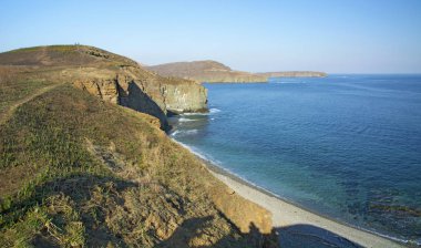 Denizden yüksek cliff, uçurumun denizin çoğu sıçramasına dalgalar ve taşlar iner.