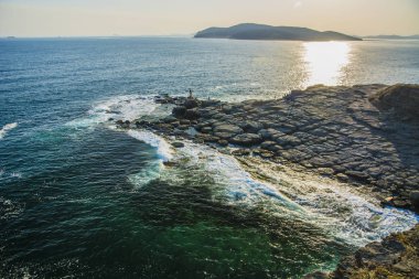 Denizden yüksek cliff, uçurumun denizin çoğu sıçramasına dalgalar ve taşlar iner.