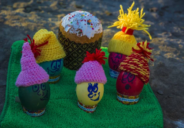 Huevos de Pascua en gorras, con caras graciosas en la naturaleza — Foto de Stock