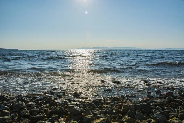 El sol se pone al mar, las olas en la costa en parches soleados —  Fotos de Stock
