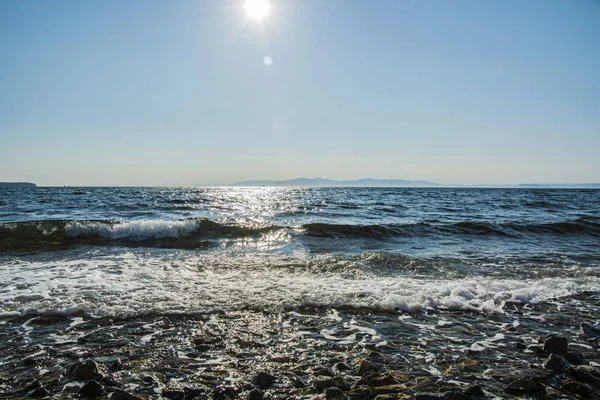 El sol se pone al mar, las olas en la costa en parches soleados —  Fotos de Stock