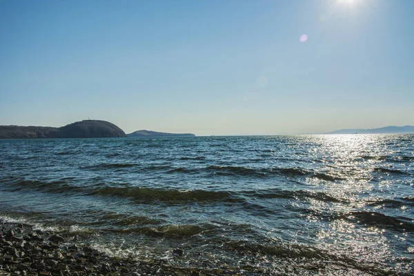 El sol se pone al mar, las olas en la costa en parches soleados —  Fotos de Stock