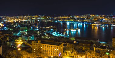 gece görünümü şehrin ışıkları bir sürü gemi ve su üzerinde parlama yansıyan