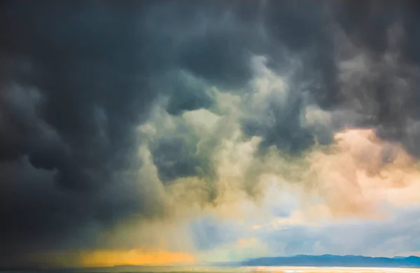 Over de zee gaat storm, dikke wolken hangen over het water — Stockfoto