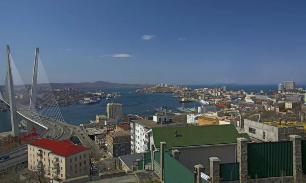 El puente sobre la bahía, en la ciudad portuaria. día soleado y floreciente vegetación — Foto de Stock