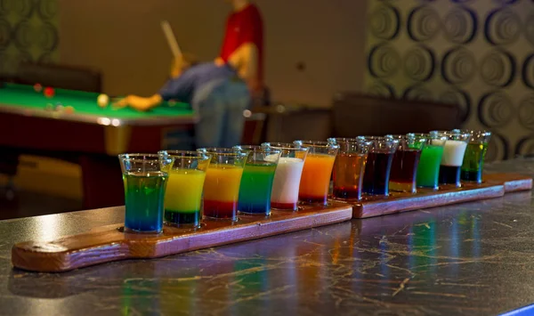 Sobre una mesa de billar con copas de color de alcohol . —  Fotos de Stock