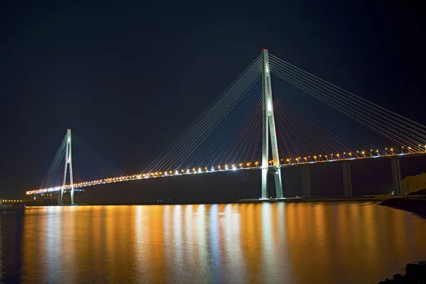 Beautiful night city lights. high bridge across the Bay stretched on pylons. — Stock Photo, Image
