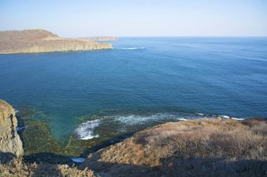 Güçlü kaya, görkemli kayalar ile güneş parlamayı, mavi bir denizde daraltır
