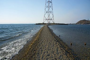 dolu deniz deniz feneri deniz plaj çizgisinin ortasındaki yolu geçer 