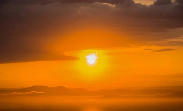 Яскраво-червоний захід сонця над морем, після шторму. Червоний захід сонця над водою і багато хмар . — стокове фото