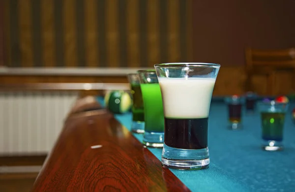 Sobre una mesa de billar con copas de color de alcohol . —  Fotos de Stock