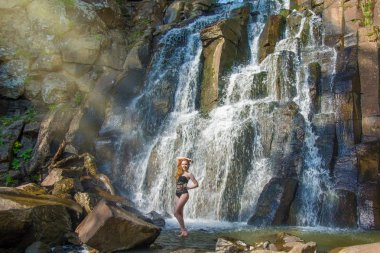 yüksek bir şelale içinde bir şelale kesinlikle ıssız Kızıl saçlı kız poz güzel kız.