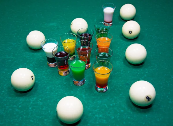 Op een biljart tafelstandaard met gekleurde glazen alcohol. — Stockfoto