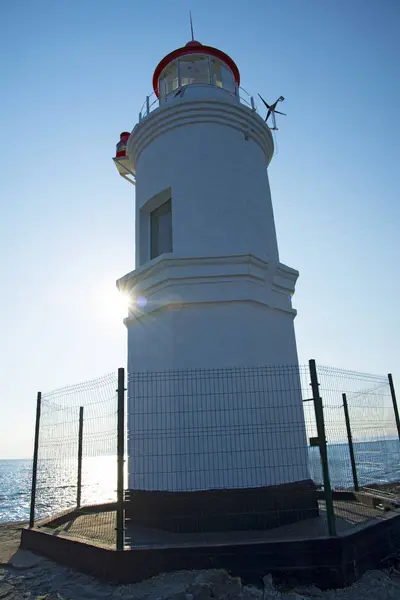 A lighthouse stands on a raised platform in the middle of the sea — Stock Photo, Image