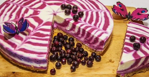 beautiful bright cake with currants, white with purple cake adorned with berries,