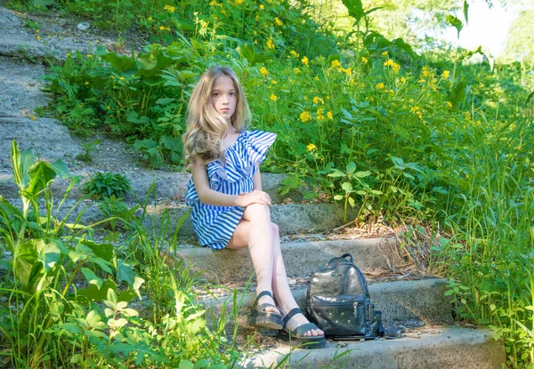 Młoda piękna dziewczyna, siedząc na schodach w parku z kwiatem, — Zdjęcie stockowe