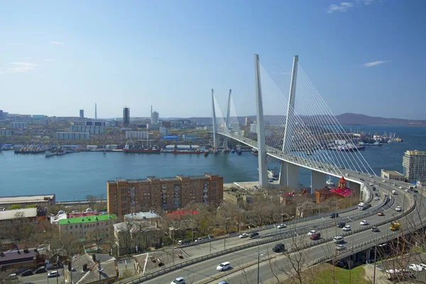 El puente sobre la bahía, en la ciudad portuaria. día soleado y floreciente vegetación — Foto de Stock