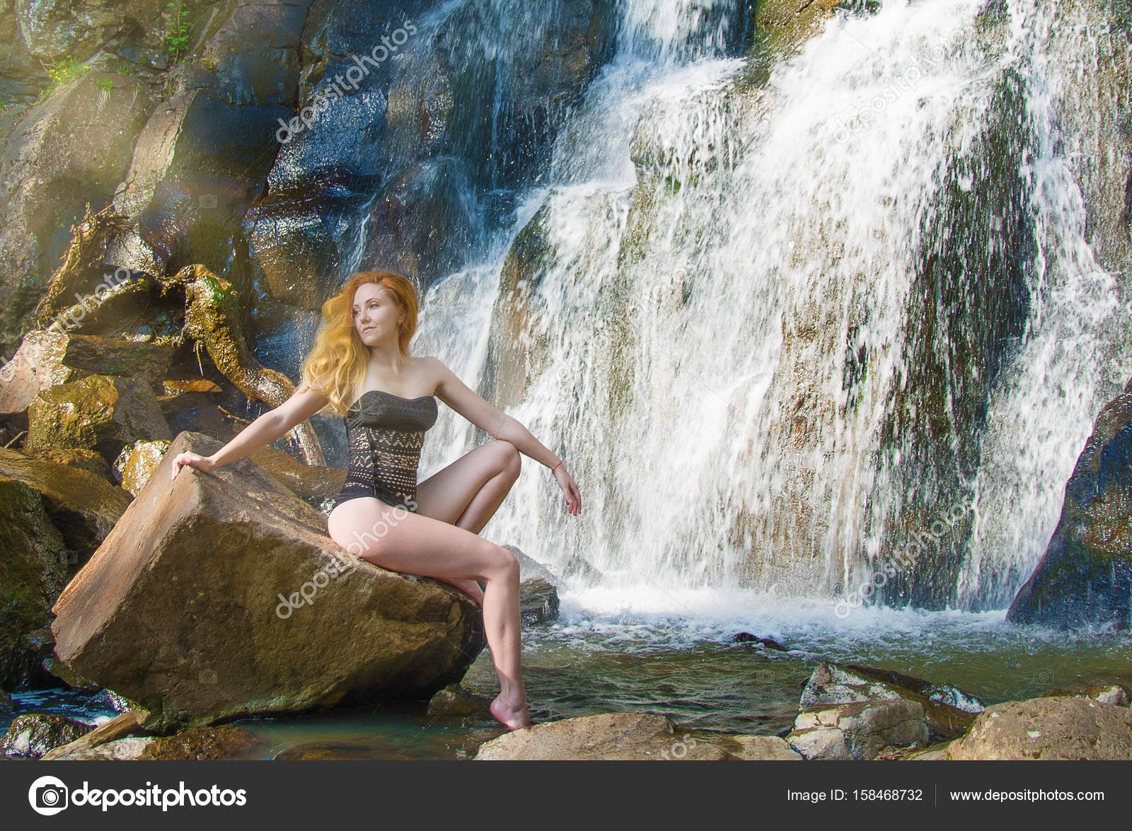 Beautiful girl posing in a high waterfall, absolutely ... Beautiful girl posin